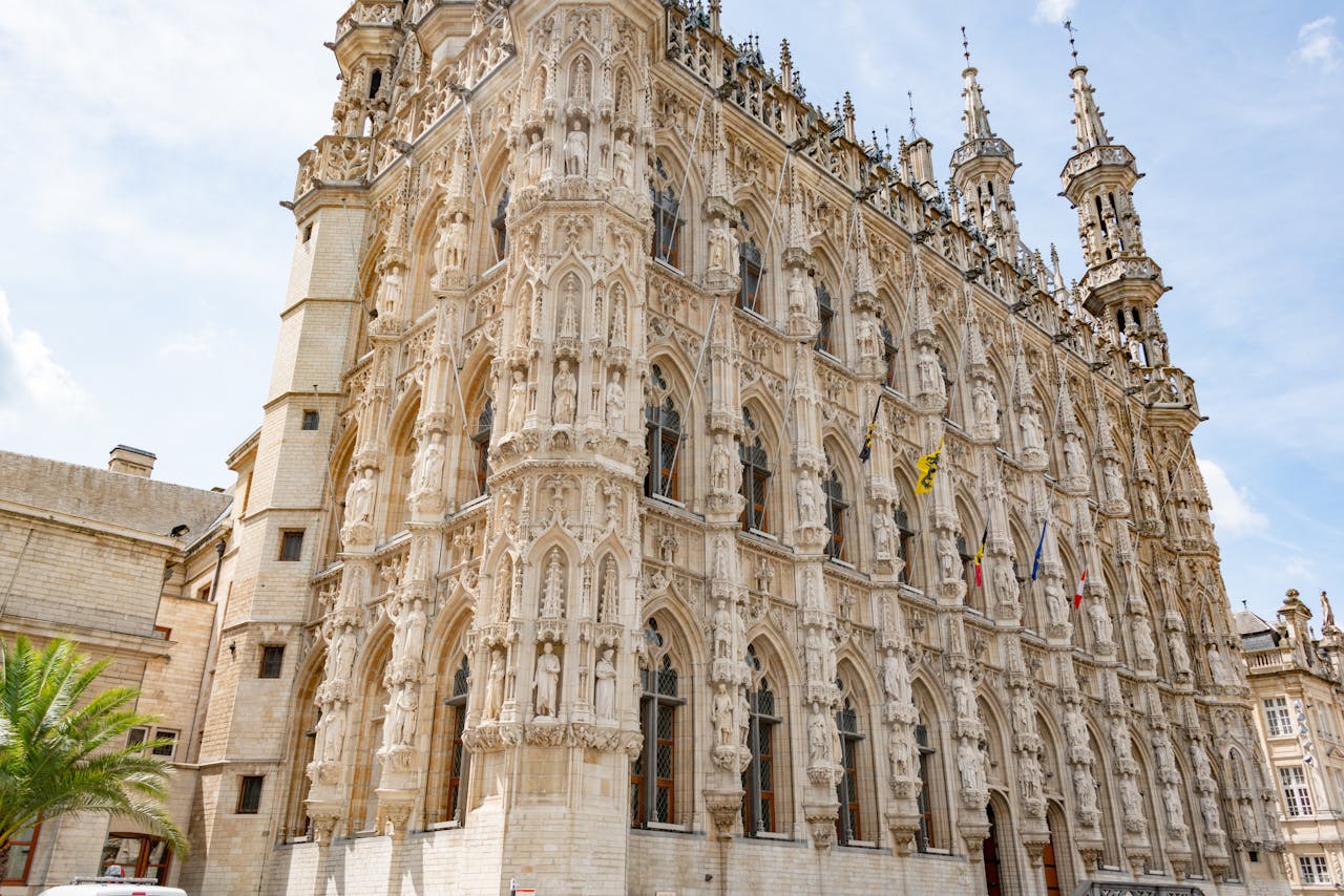 Low angle view of the ornate Gothic facade of Leuven Town Hall in Belgium.