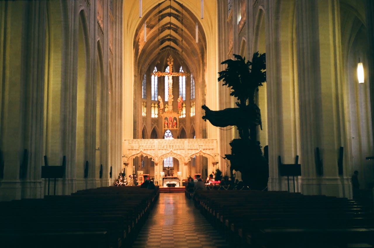 Explore the serene interior of a historic Gothic cathedral featuring a grand altar and illuminated cross.